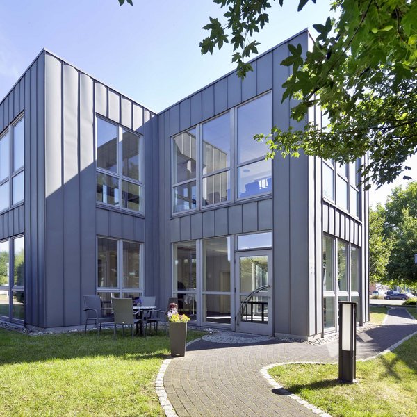 Median Hotel Hannover Lehrte Modern office building with large windows and outdoor seating area