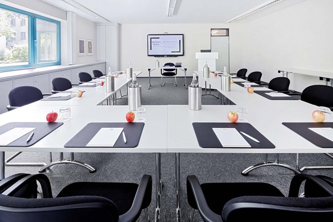 Hybrides Tagen in Lehrte Helles, modernes Konferenzzimmer mit U-förmigen Tischen und vorbereiteten Arbeitsplätzen