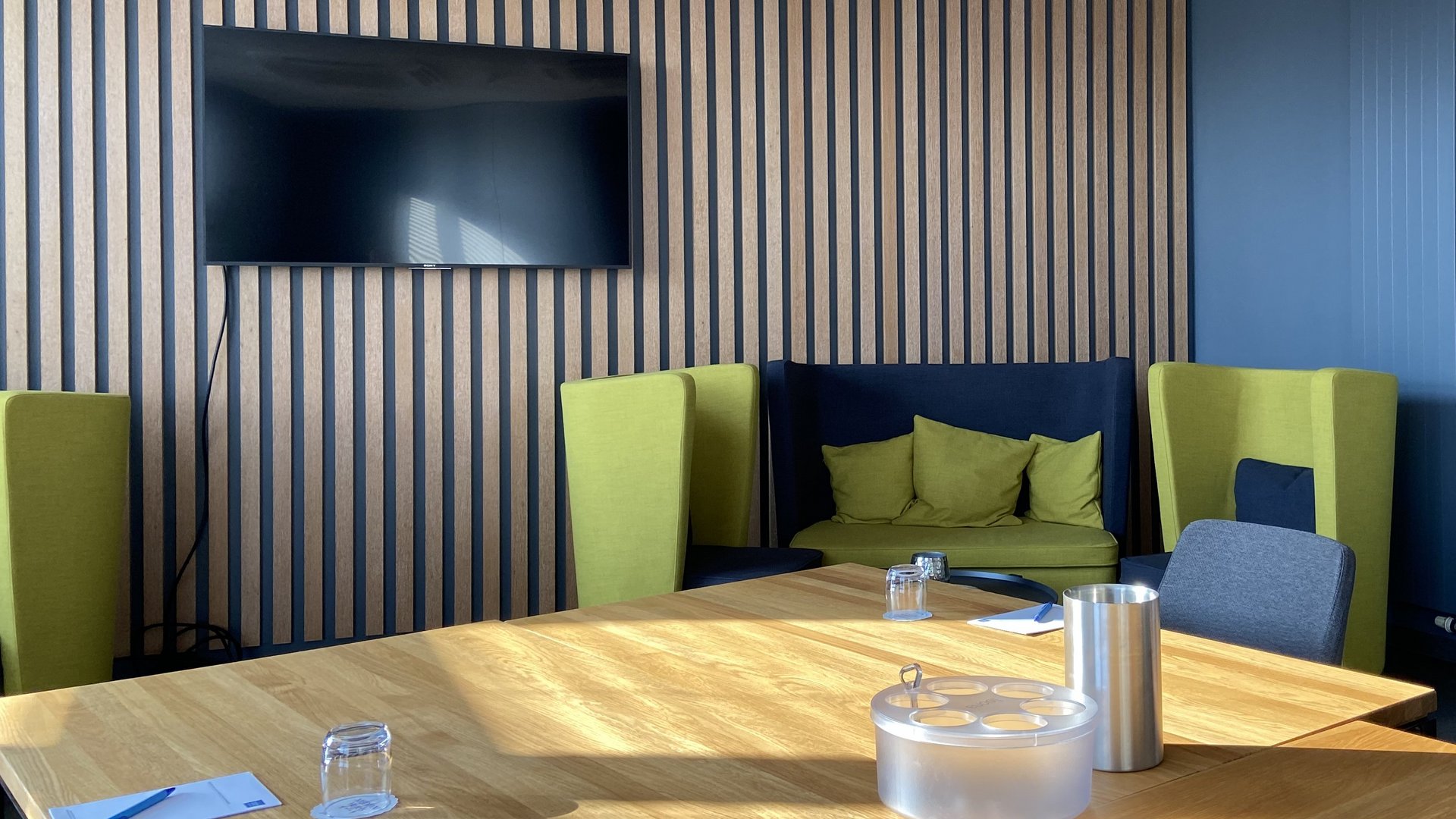 Ihr Tagungshotel in Hannover Moderner Besprechungsraum mit Fernseher und bequemen Stühlen