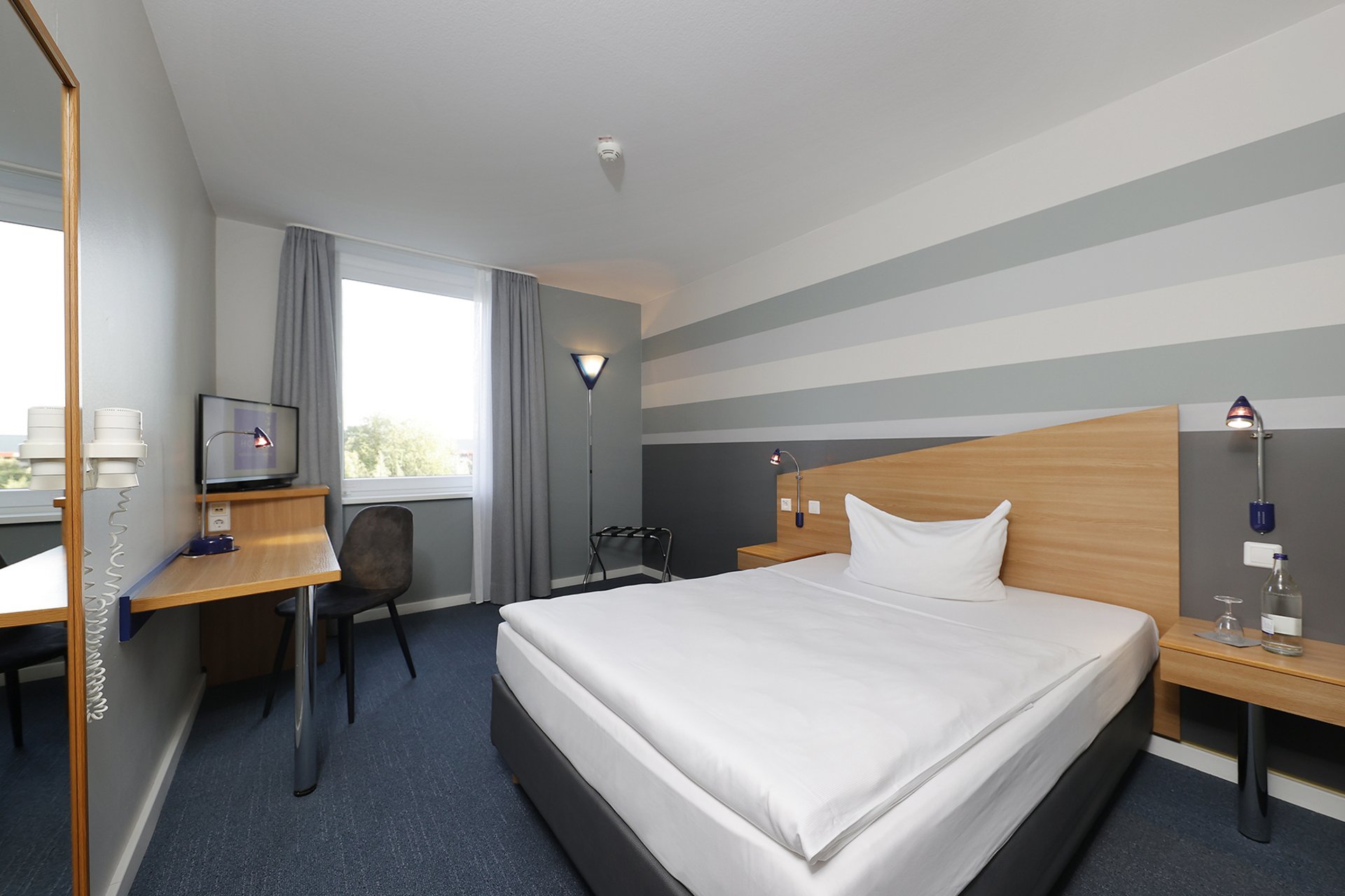 Our hotel at the exhibition centre: the picture gallery Cozy hotel room with single bed, desk, and window with curtains