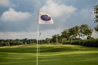 Golfwochenende inklusive Golfturnier Golfplatz mit Fahnen und grünem Gras unter blauem Himmel