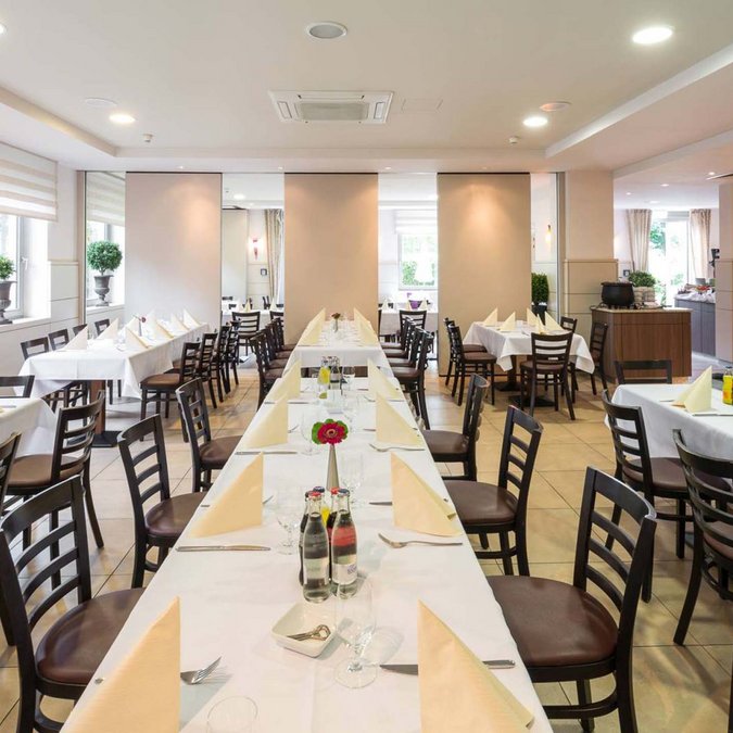 Hanover: food and drinks at the Median Hotel in Lehrte Bright dining room with white tablecloths and set tables