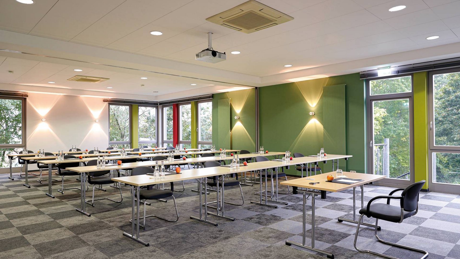 Welcome to the Median Hotel Hannover Messe! Conference room with tables, chairs, water bottles, apples, bright walls and windows