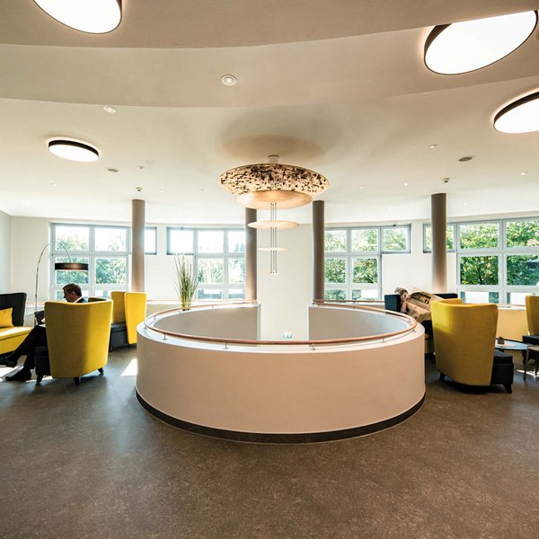 Median Hotel Hannover Lehrte Modern lounge with yellow chairs and large windows on a bright day
