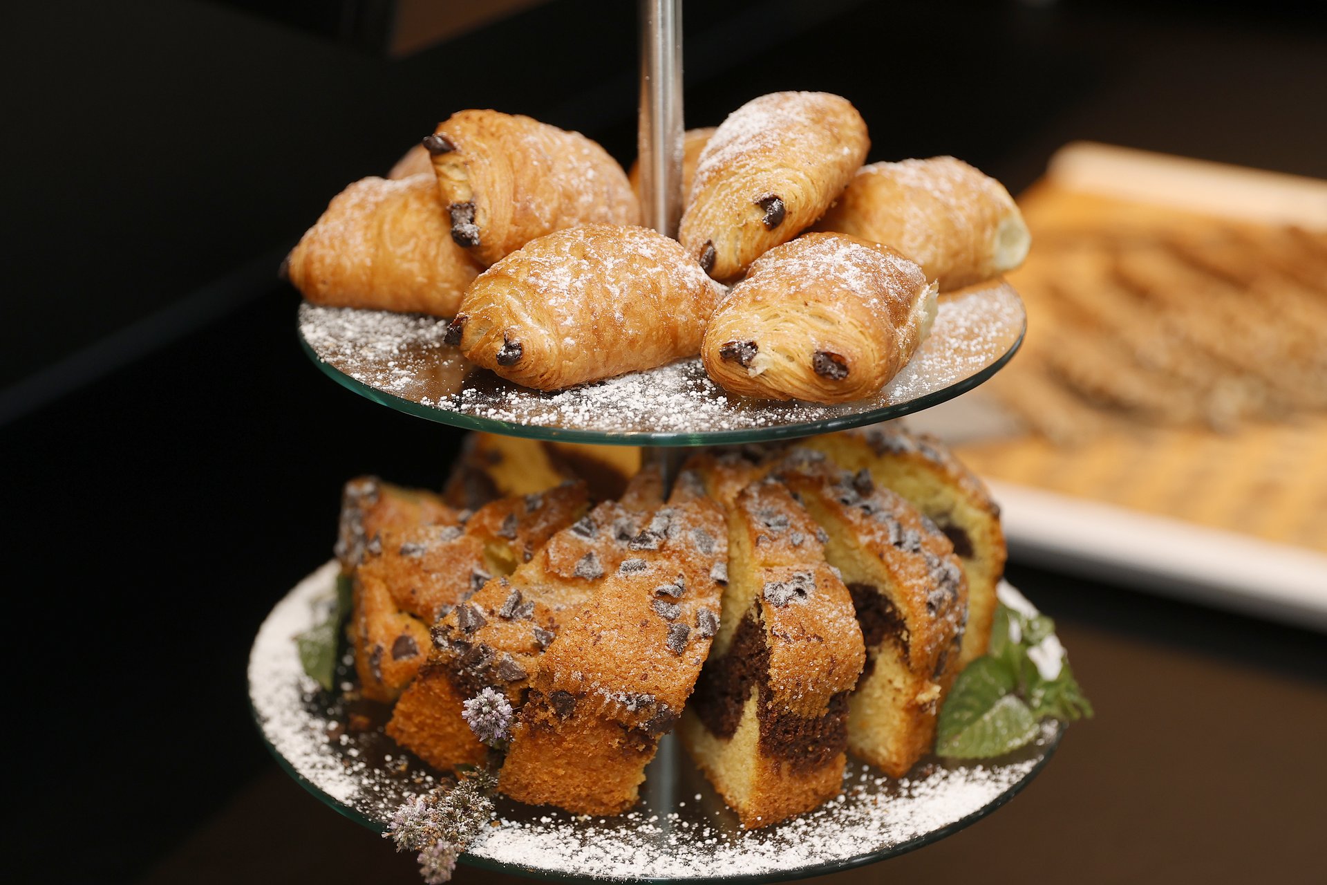 Unser Hotel an der Messe: die Bildergalerie Zweistöckiges Tablett mit Mini-Schokocroissants und Schokoladenkuchenstücken