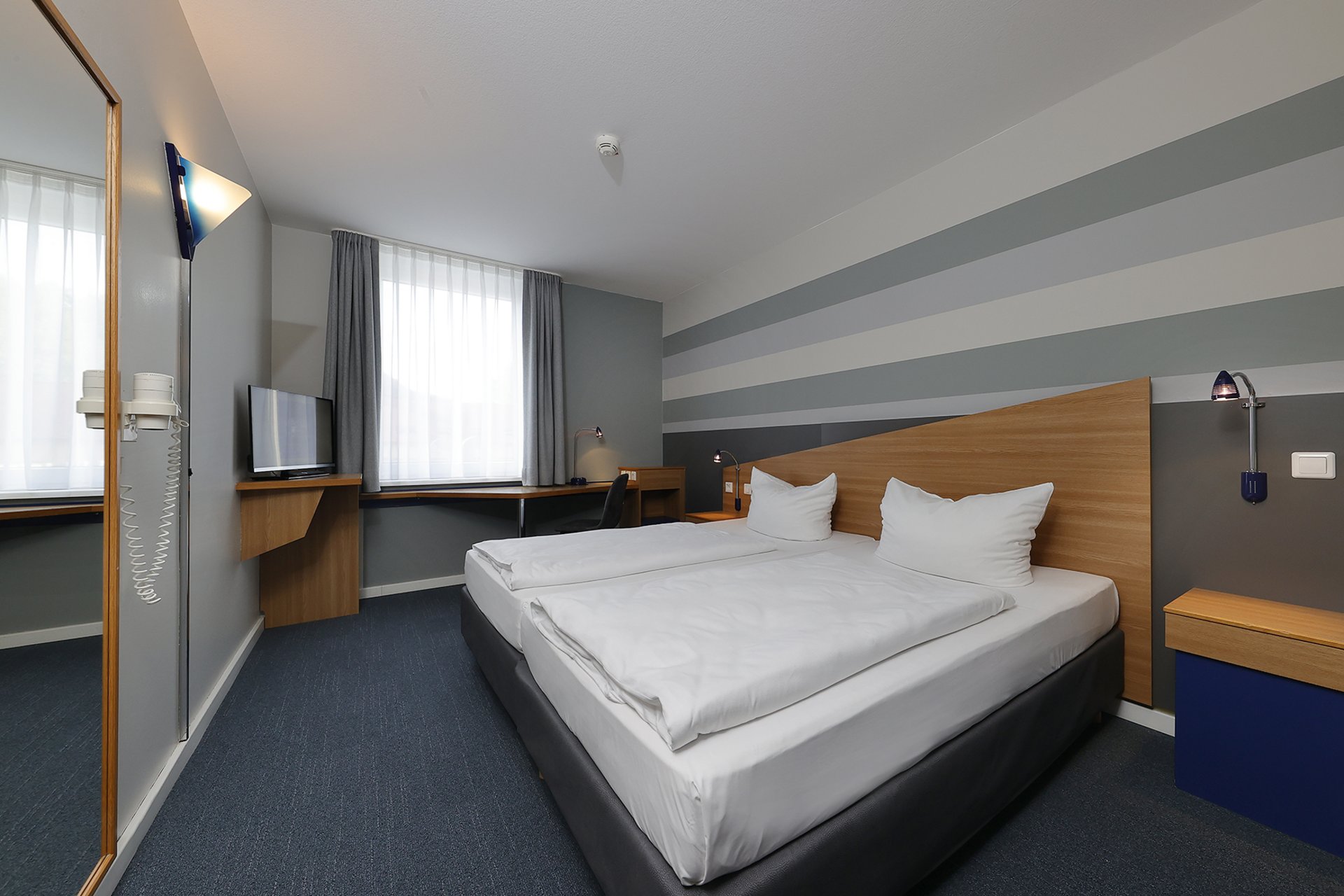 Our hotel at the exhibition centre: the picture gallery Modern hotel room with two single beds, desk, and television