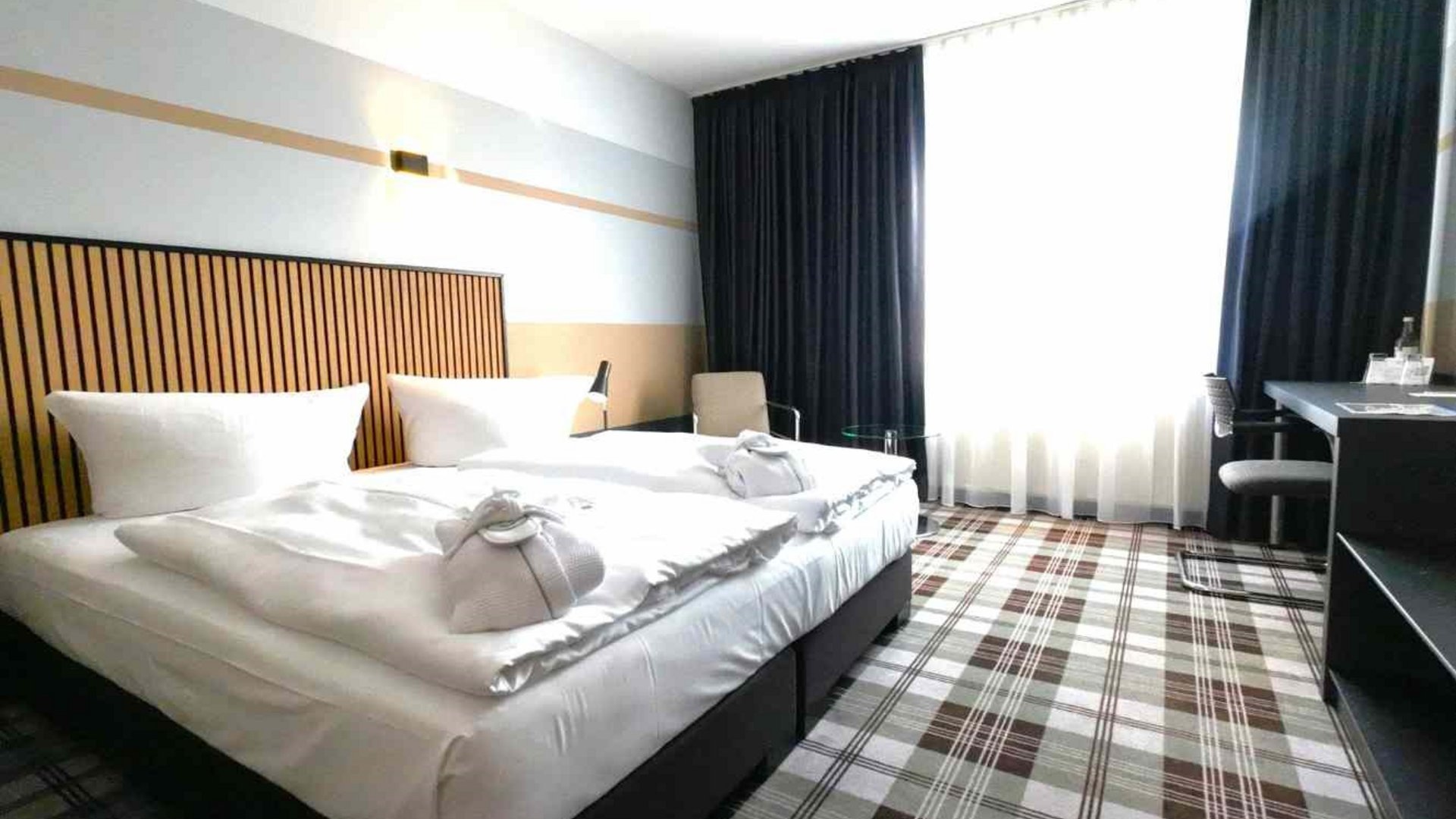 Golfwochenende inklusive Golfturnier Modernes Hotelzimmer mit zwei Betten und kleinem Arbeitstisch