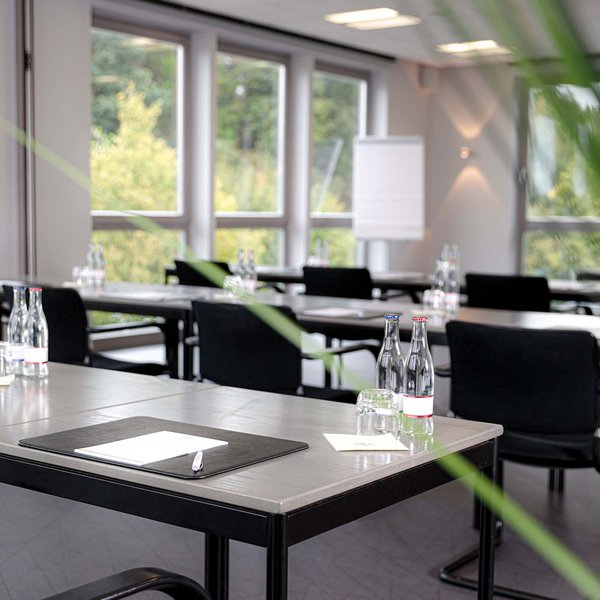 Median Hotel Hannover Lehrte Modern conference room with tables, chairs, water bottles, and notepads