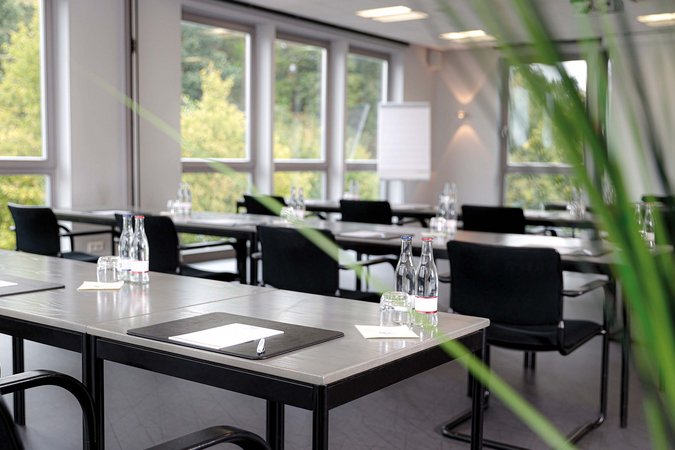 Hybrides Tagen in Lehrte Moderner Konferenzraum mit Tischen, Stühlen, Wasserflaschen und Notizblöcken