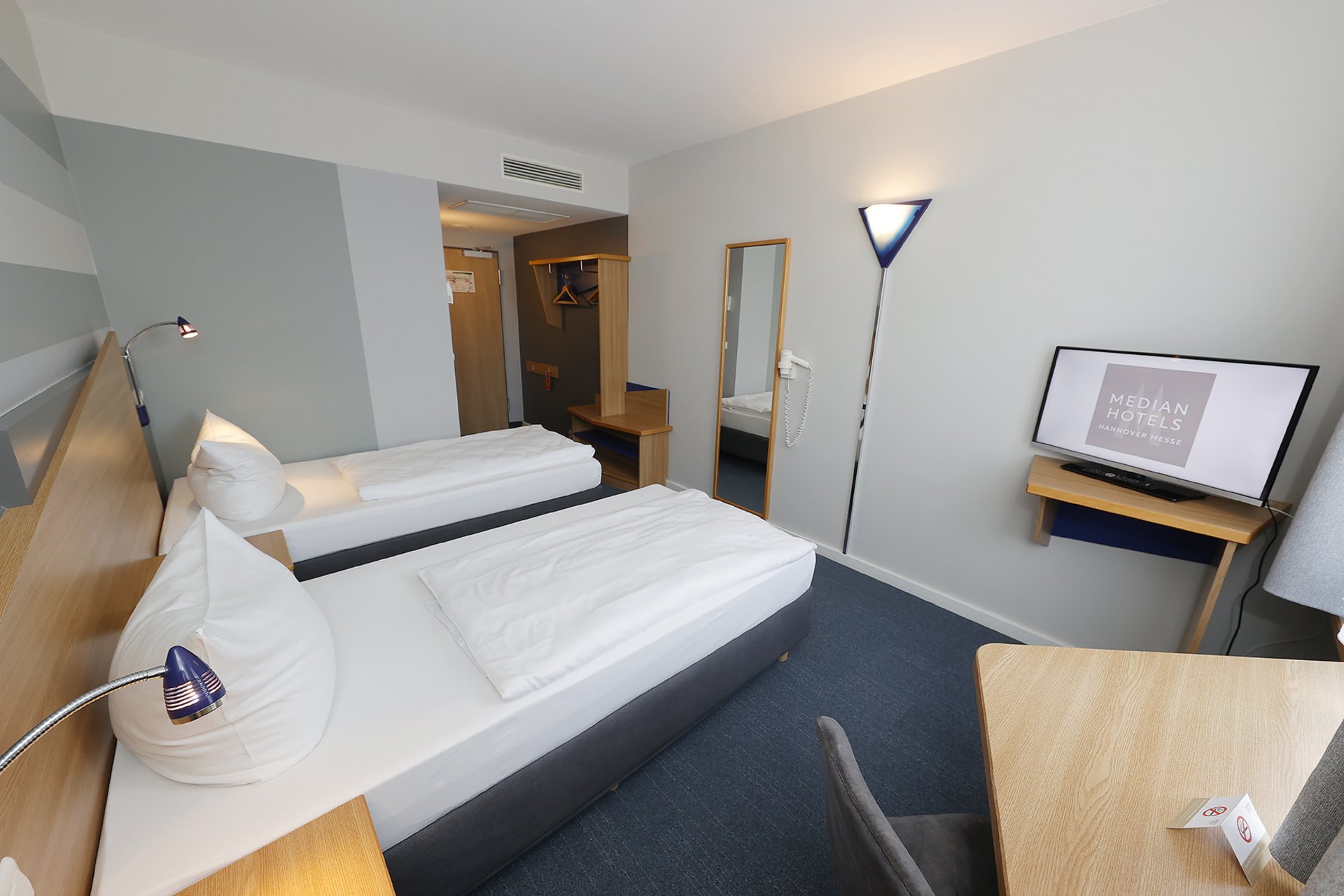 Unser Hotel an der Messe: die Bildergalerie Modernes Hotelzimmer mit zwei Einzelbetten und TV