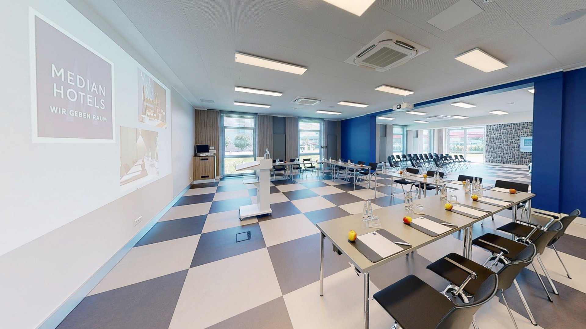 Die modernsten Tagungsräume in Hannover Moderner Tagungsraum mit Projektor, Stühlen und vorbereitetem Tisch in Hotel