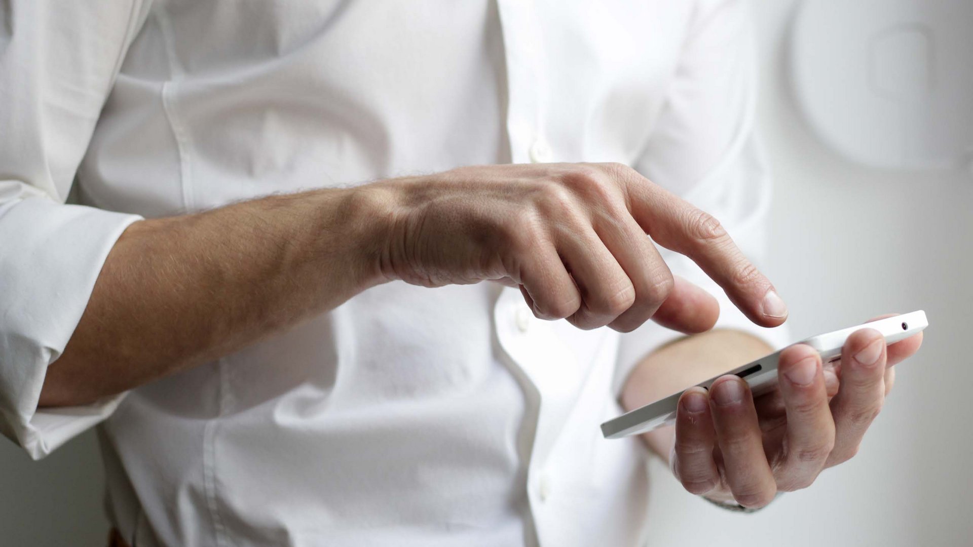 Ihre App für alle Fälle Person bedient Smartphone mit einer Hand, trägt weißes Hemd