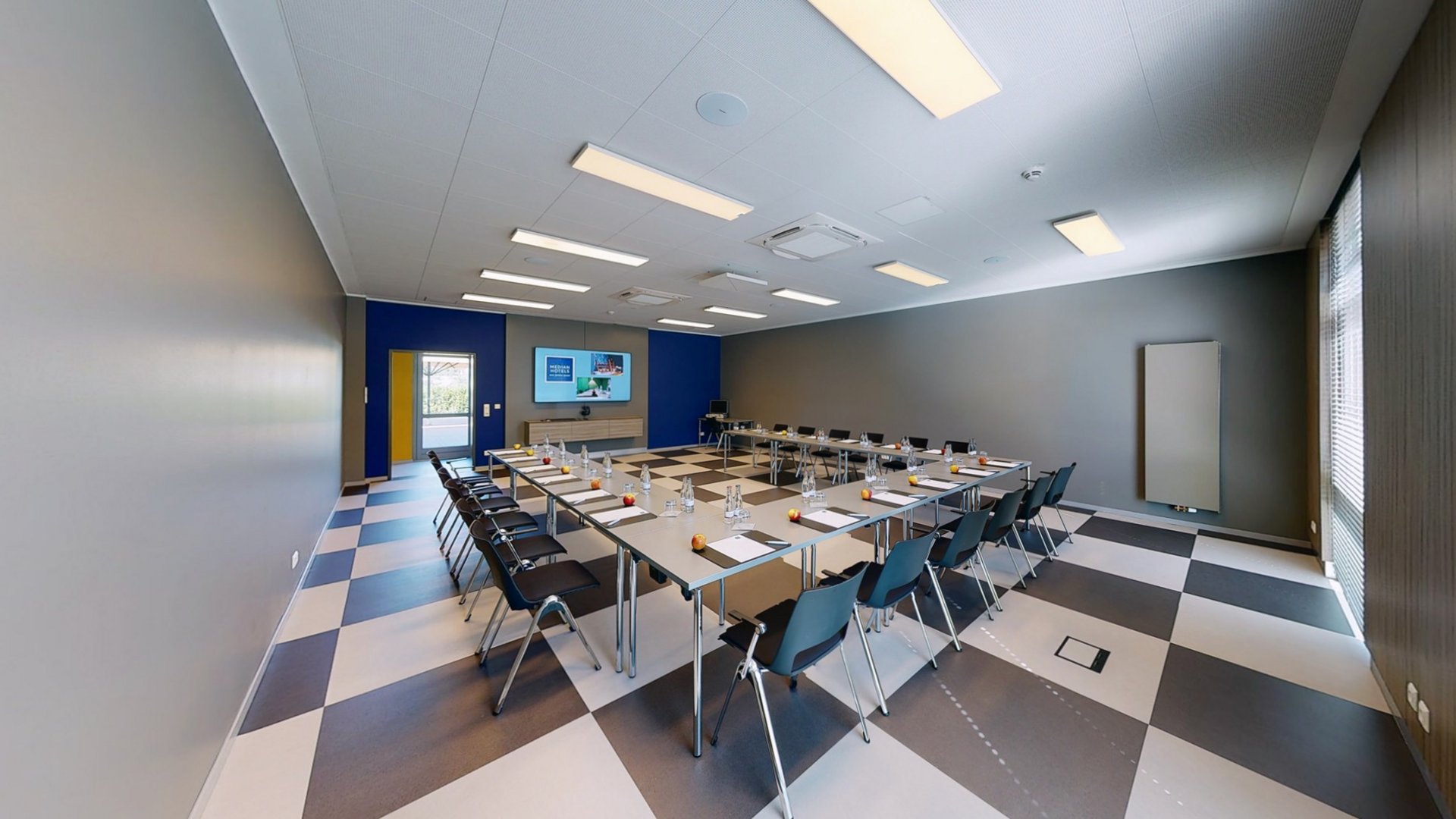 Ihr autarker und exklusiver Tagungsbereich: Ihr Hotel im Hotel Moderner Konferenzraum mit U-förmigen Tischen, Stühlen, Flachbildschirm und Wasserflaschen