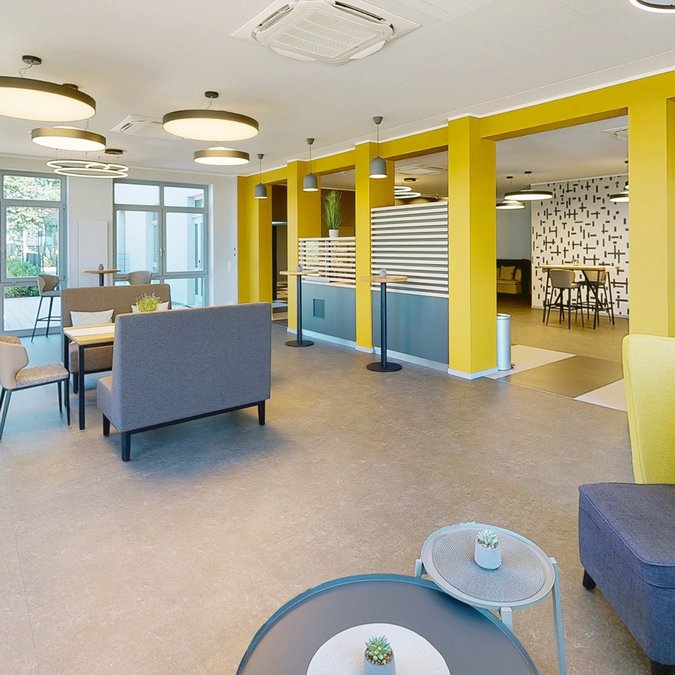Median Hotel in Lehrte – we provide space Modern lounge area with yellow pillars and seating spaces