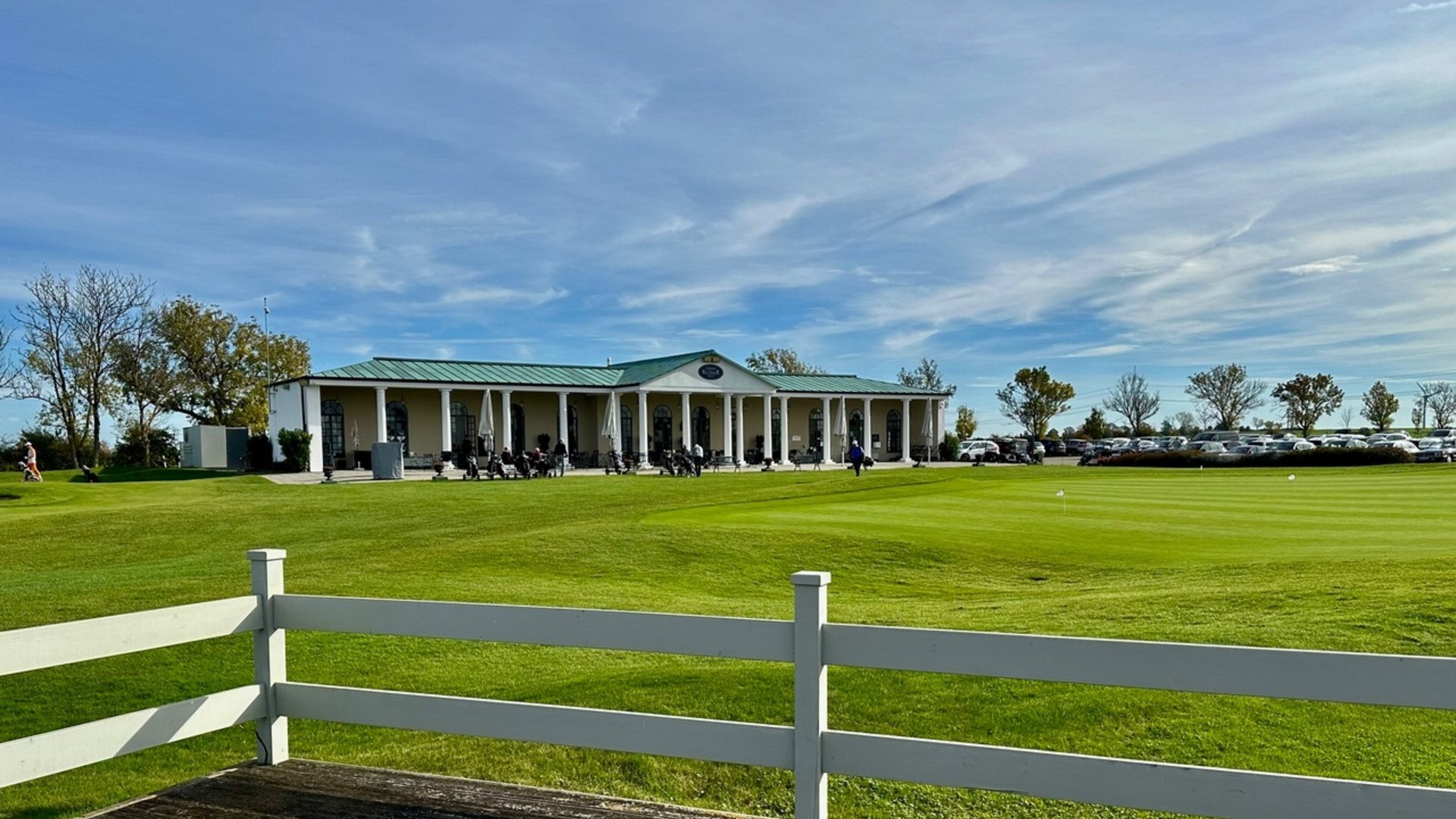 Golfwochenende inklusive Golfturnier Golfclubgebäude mit weißen Säulen und grünem Dach bei bewölktem Himmel